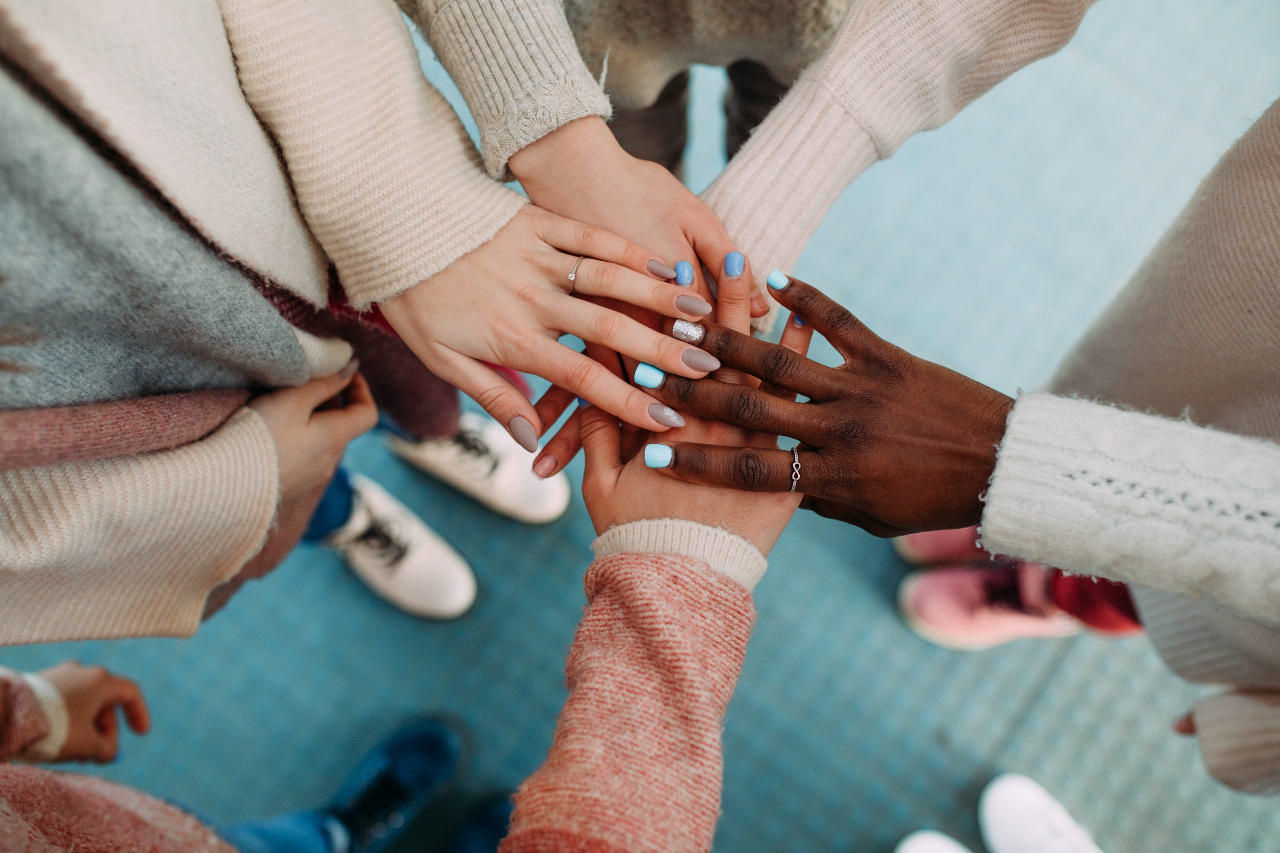 Hands of women of different races touch each other closeup showing menopause diversity