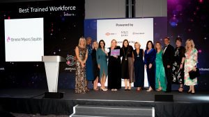 Bristol Myers Squibb on stage with Louise Minchin receiving the Best Trained Workforce Award 2022