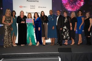 Bristol Myers Squibb, winners of The Menopause Friendly Employer of the Year Award 2022 on stage with Louise Minchin and The Rt Hon Caroline Nokes MP