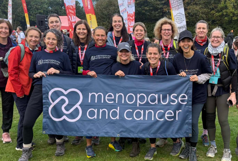 Menopause and Cancer supporters taking part in a fundraising walking event, holding a Menopause and Cancer banner.